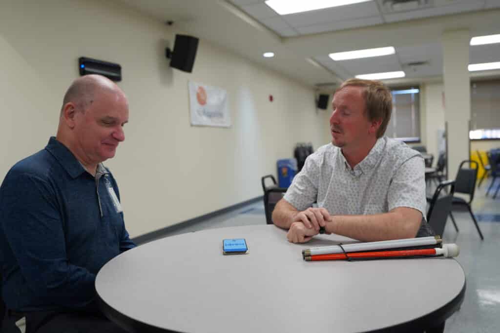 Randy talks to Cameron in the Alphapointe lunchroom. 