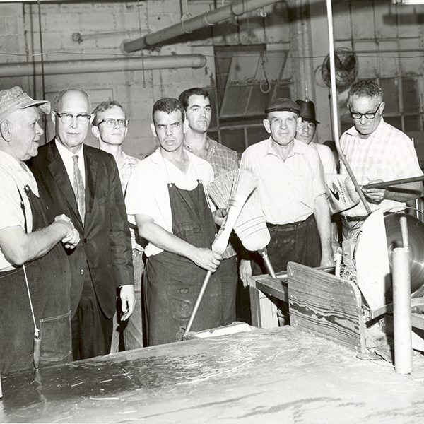 Black and white image of a few male employees in our former broom workshop 