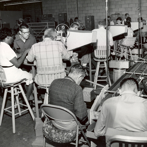 Black and white image of employees assembling pens in our former workshop
