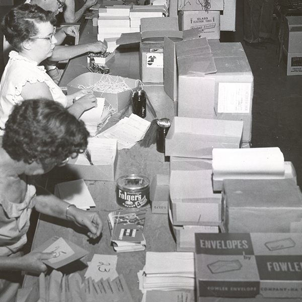 Black and white image of female employees making envelopes in our former workshop