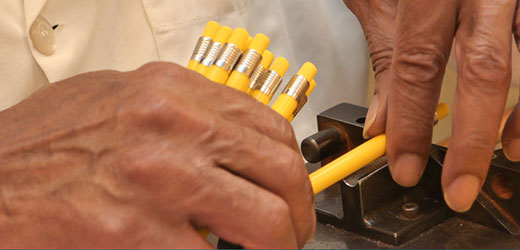 Image of hands assembling yellow wax pencils