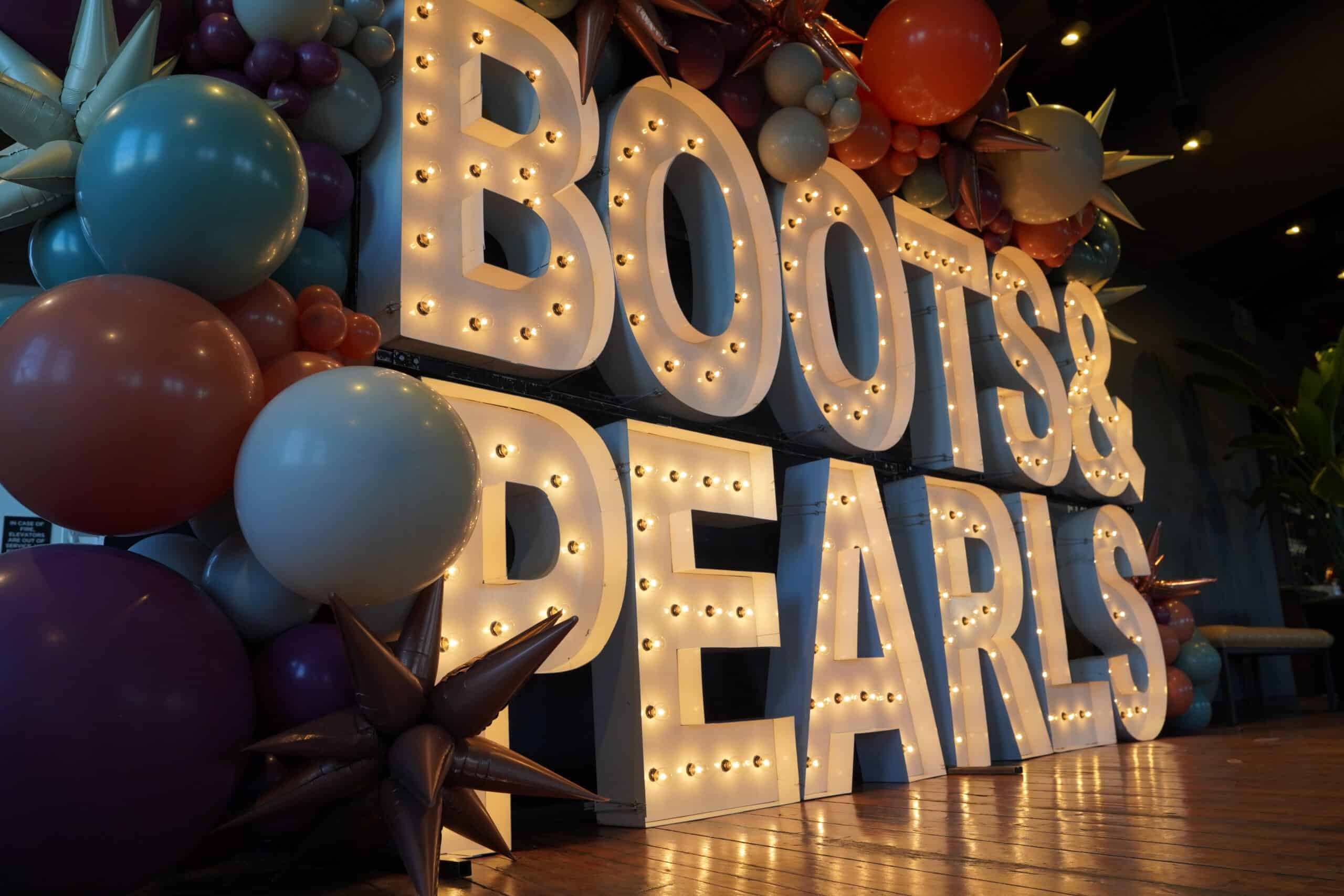 Boots & Pearls is Alphapointe's winter event, which helps raise funds for programs that support people who are blind or visually impaired. This is a sign that says Boots & Pearls.