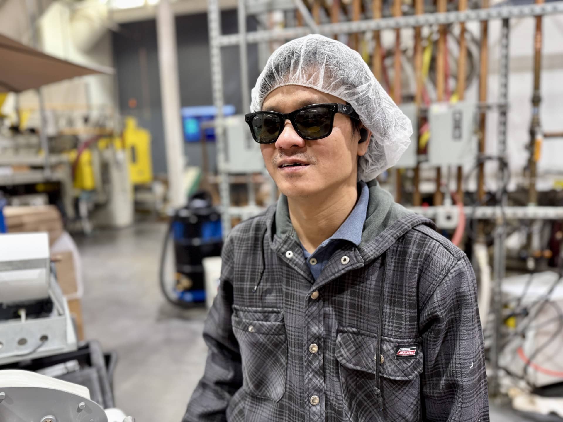 Thomas is smiling at the camera while working in the Alphapointe Plastics Department.