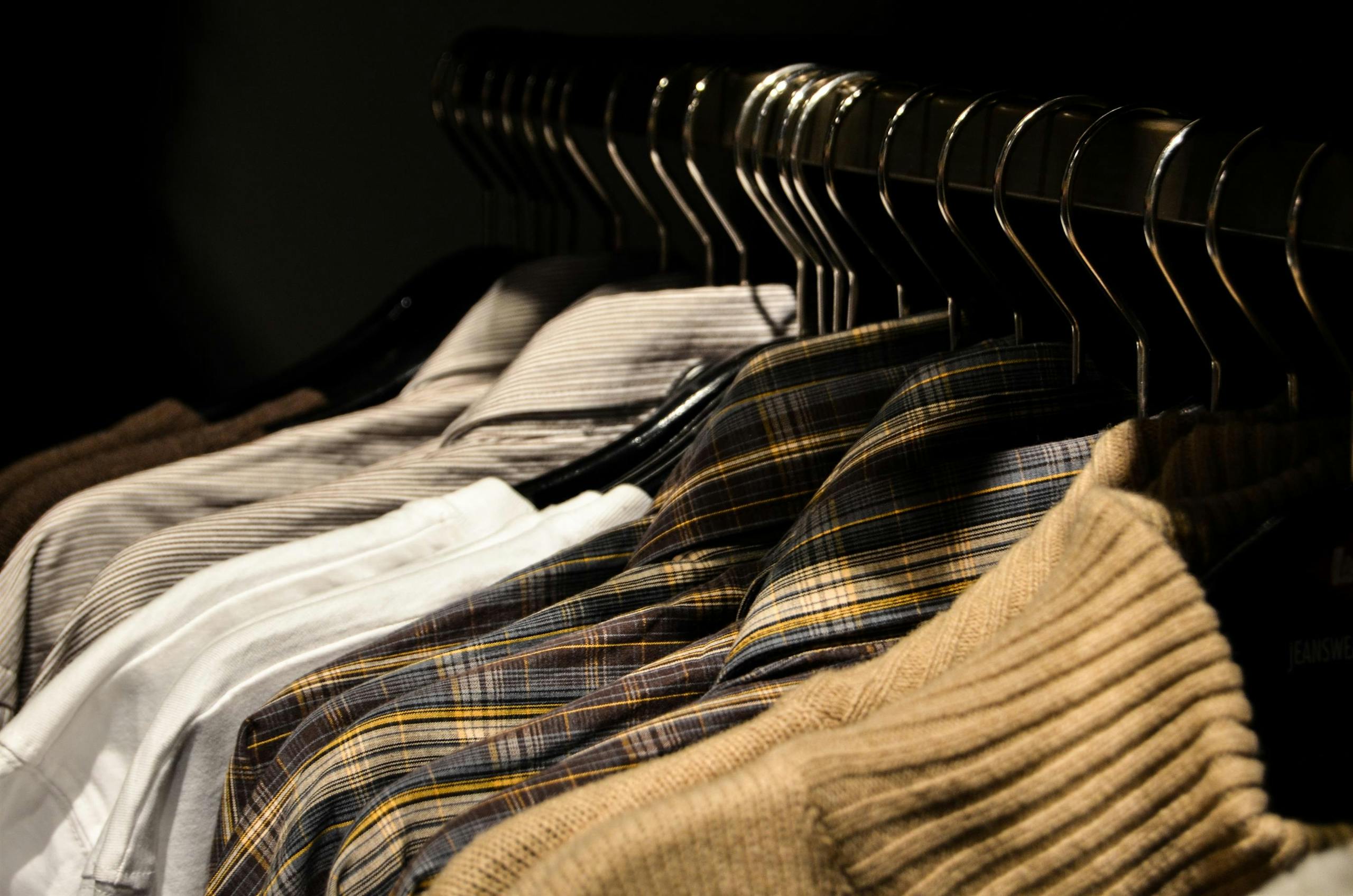 Organized display of various shirts on hangers, showcasing fashion and style.